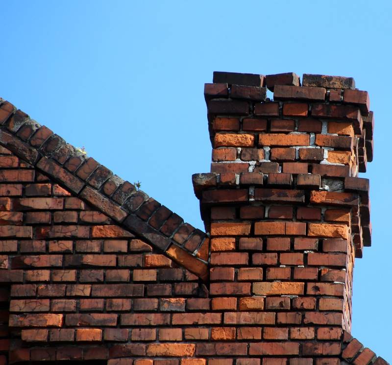 Damaged chimney on an Lombard home showing cracks and missing mortar
